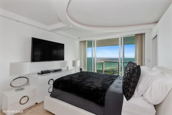 a bedroom with a bed and a flat screen tv