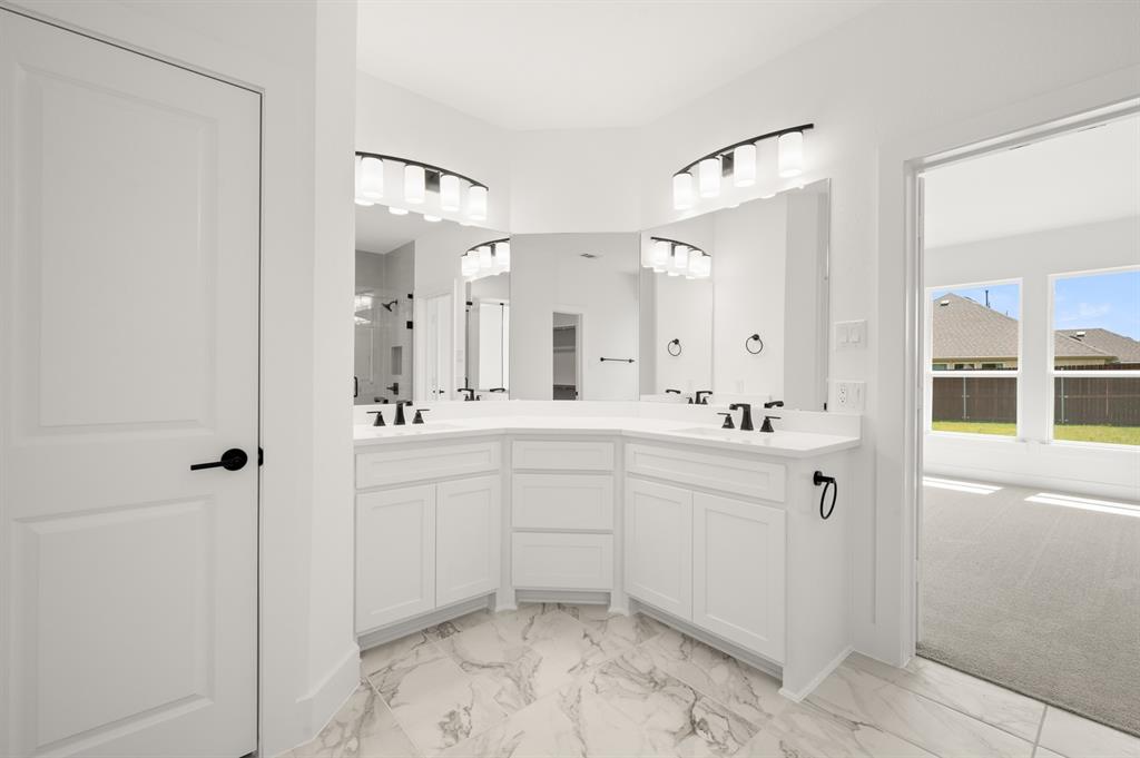 3714 Milwaukee Avenue Midlothian, TX 76065 - Photo 32 of 40 a spacious bathroom with a shower sink and mirror