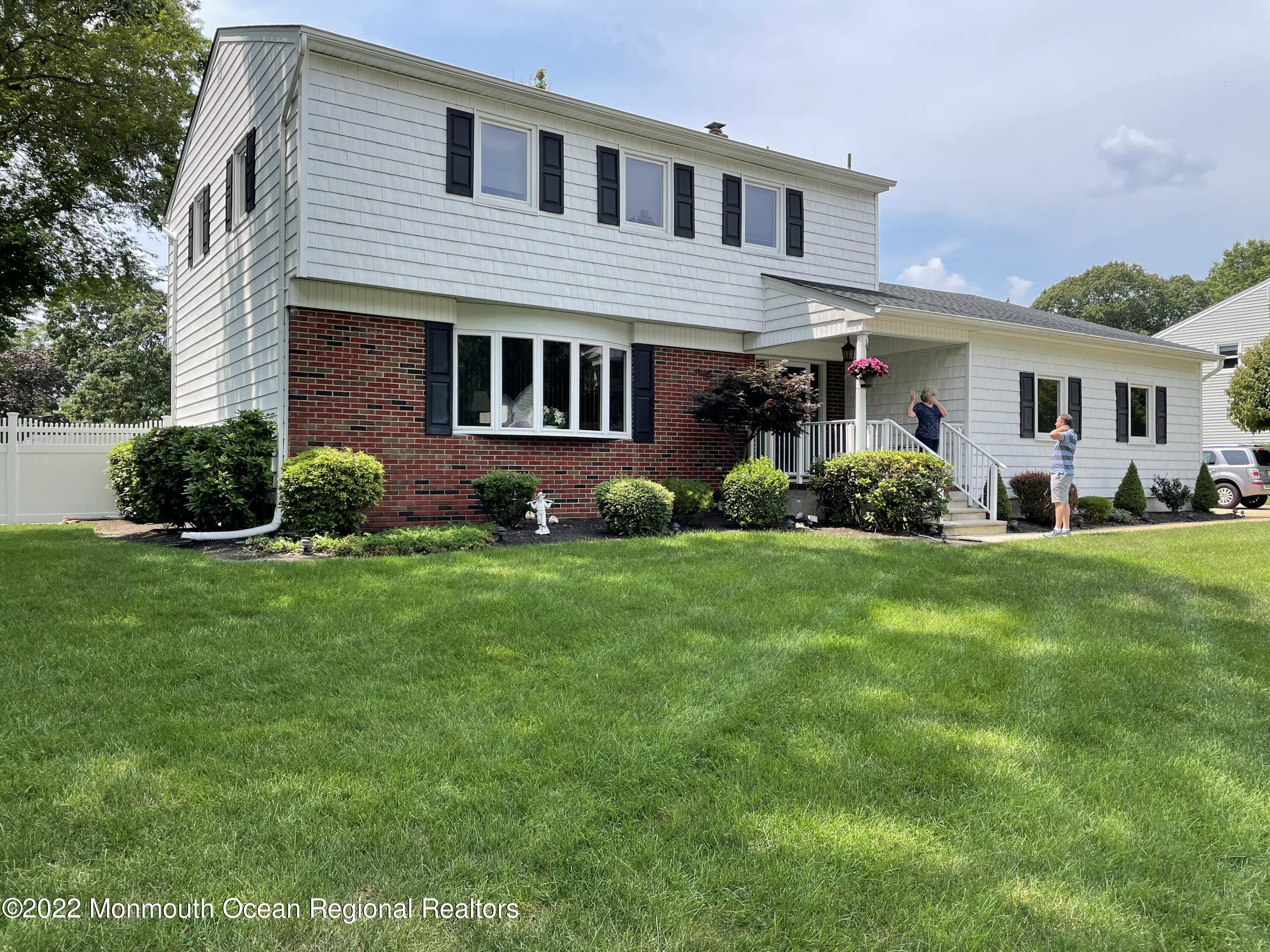 a front view of a house with a yard and green space
