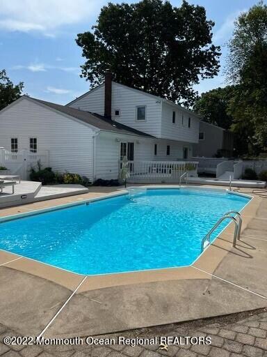 104 Pear Street, Unit WINTER Oakhurst, NJ 07755 - Photo 12 of 17 a swimming pool with outdoor seating