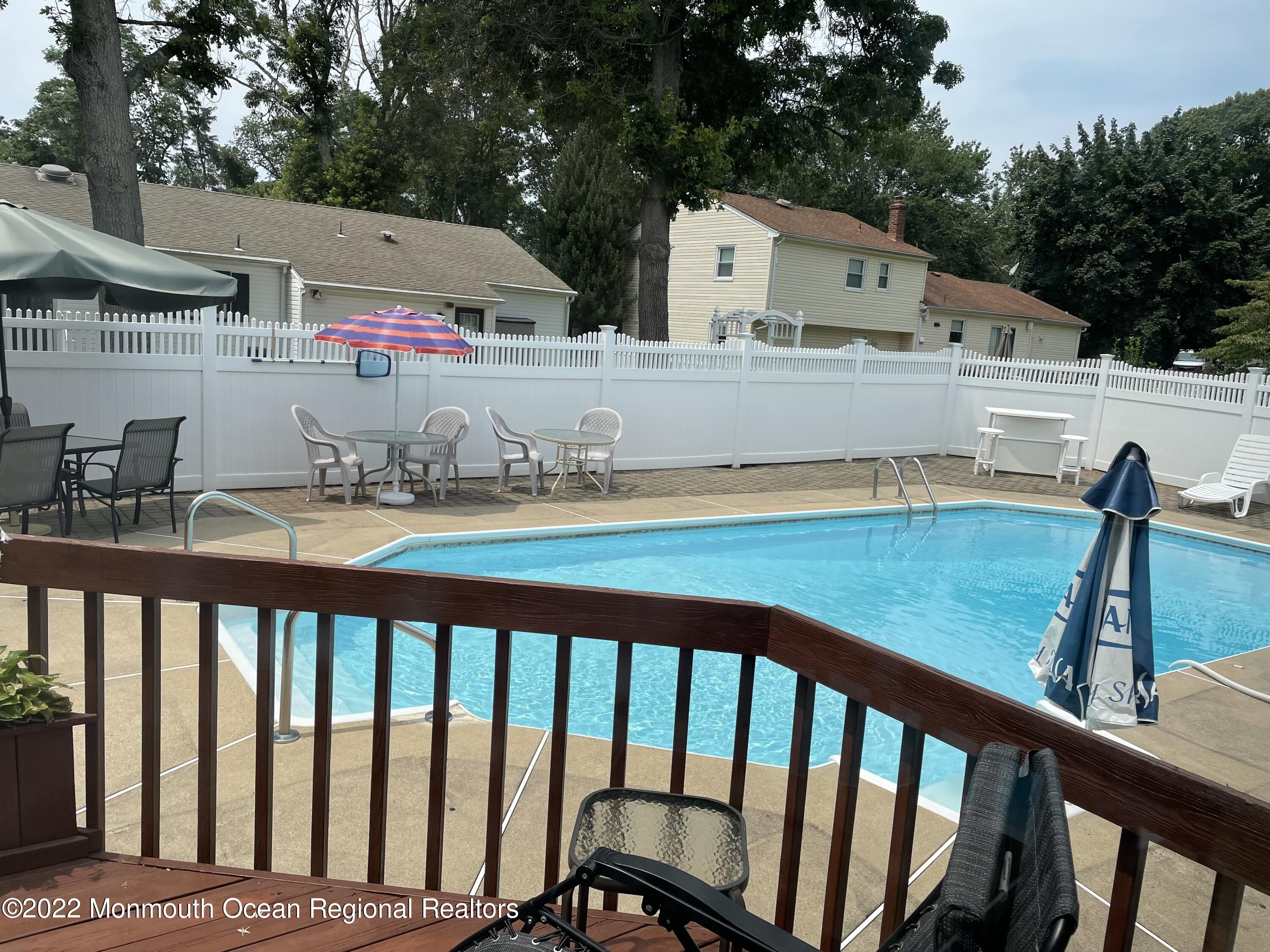 104 Pear Street, Unit WINTER Oakhurst, NJ 07755 - Photo 13 of 17 a view of a white house and a yard with wooden fence