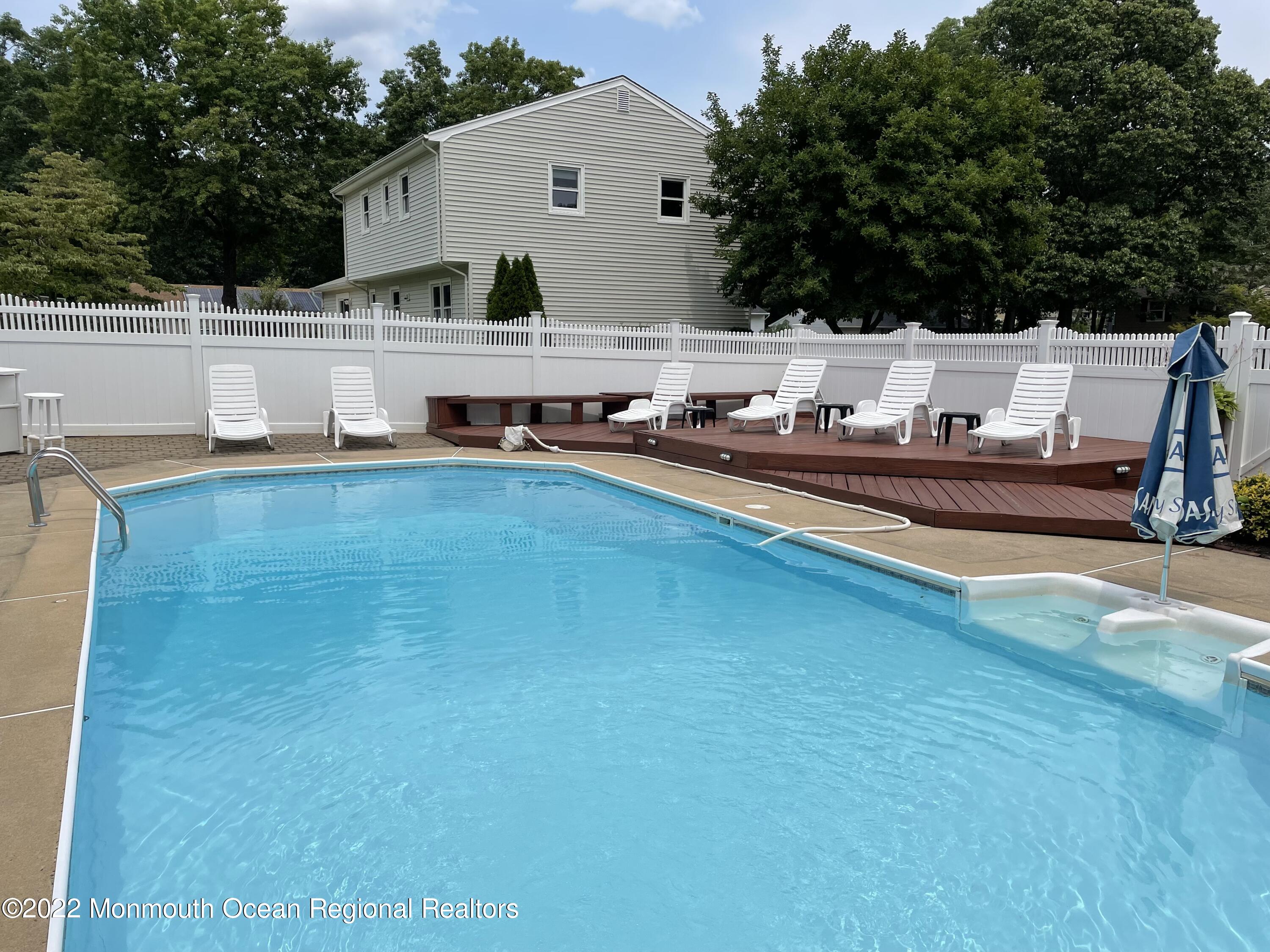 104 Pear Street, Unit WINTER Oakhurst, NJ 07755 - Photo 14 of 17 a view of a house with pool and a yard