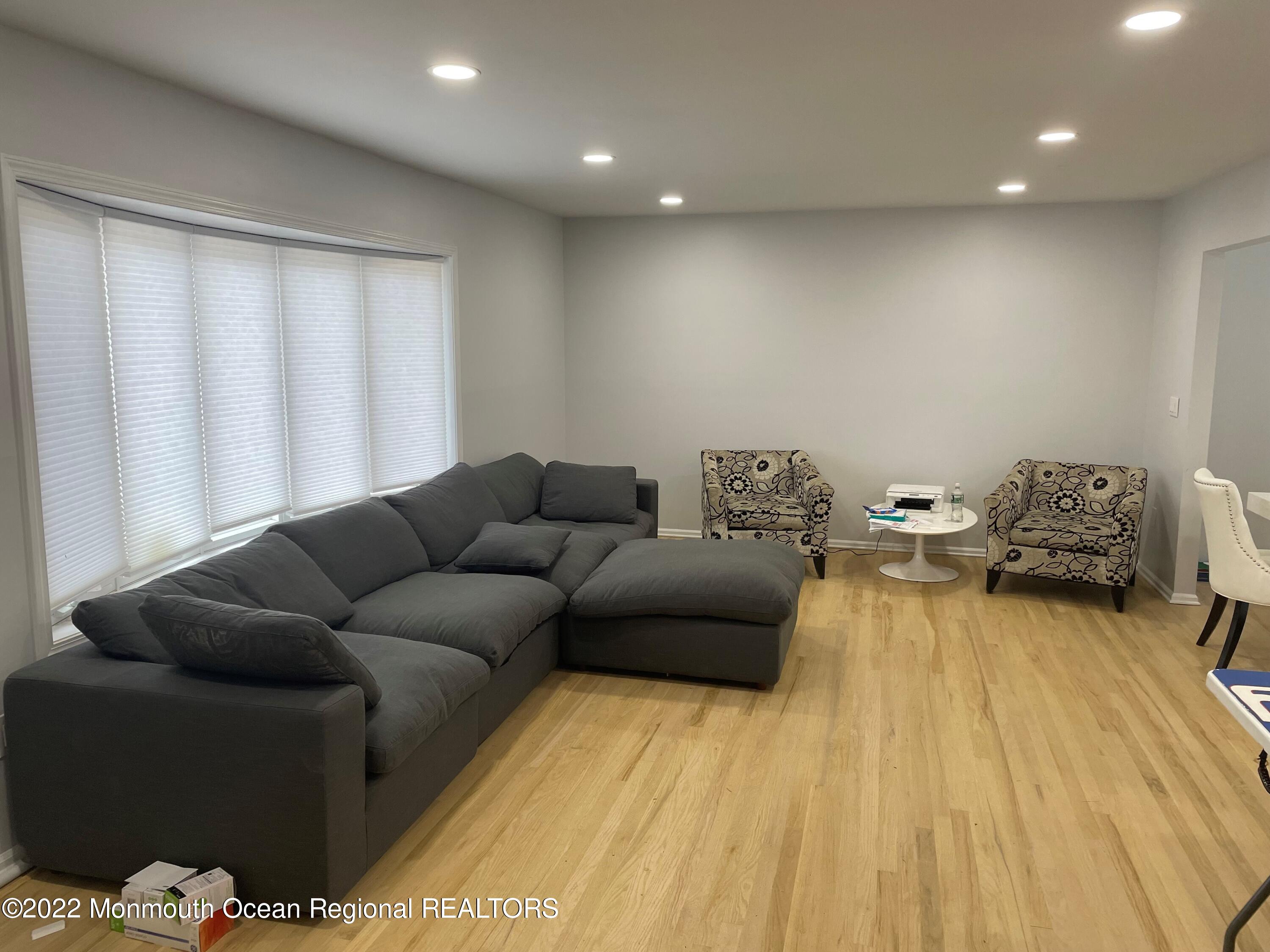 104 Pear Street, Unit WINTER Oakhurst, NJ 07755 - Photo 2 of 17 a living room with furniture and a wooden floor