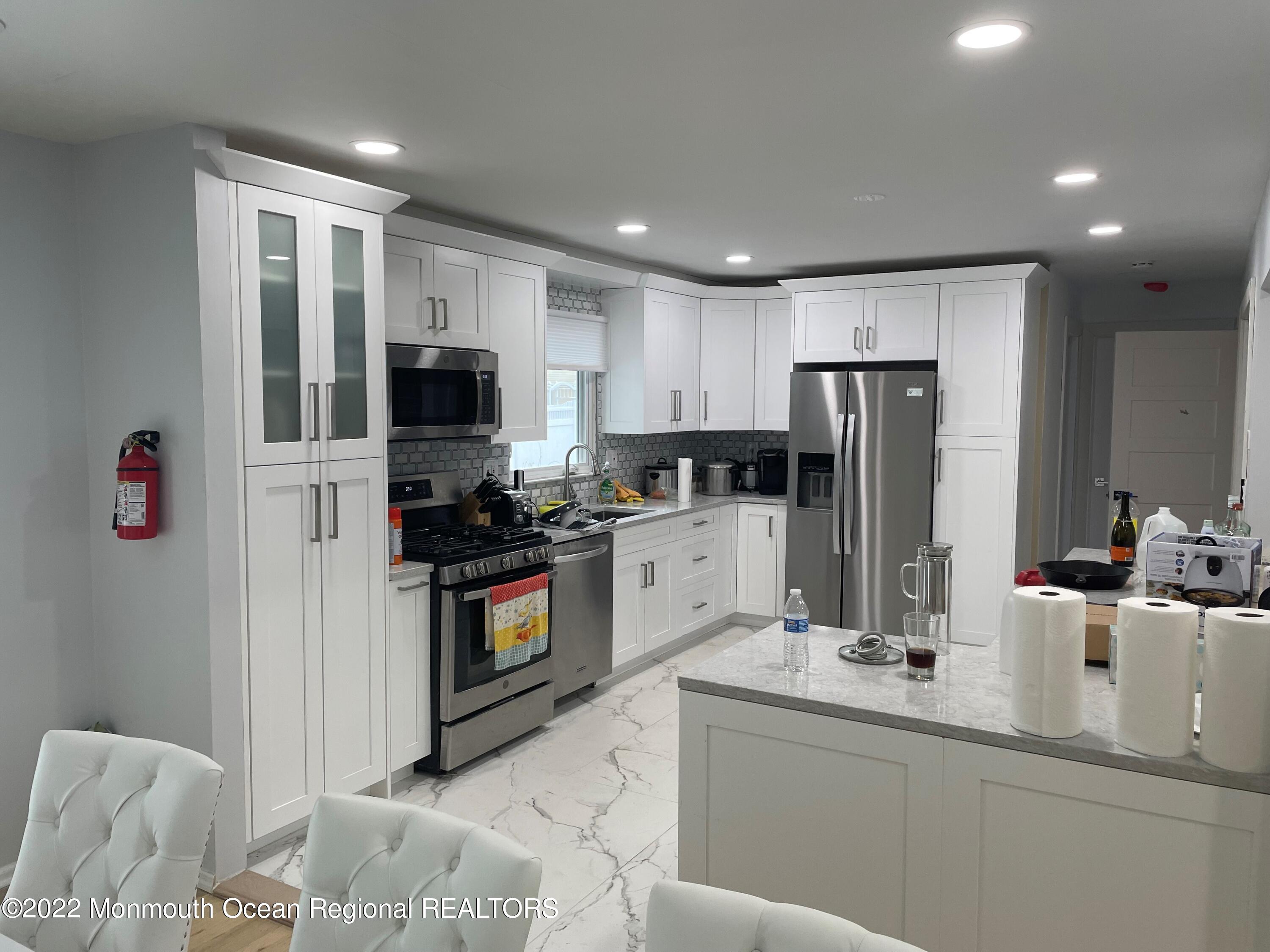 104 Pear Street, Unit WINTER Oakhurst, NJ 07755 - Photo 3 of 17 a kitchen with a sink refrigerator and microwave