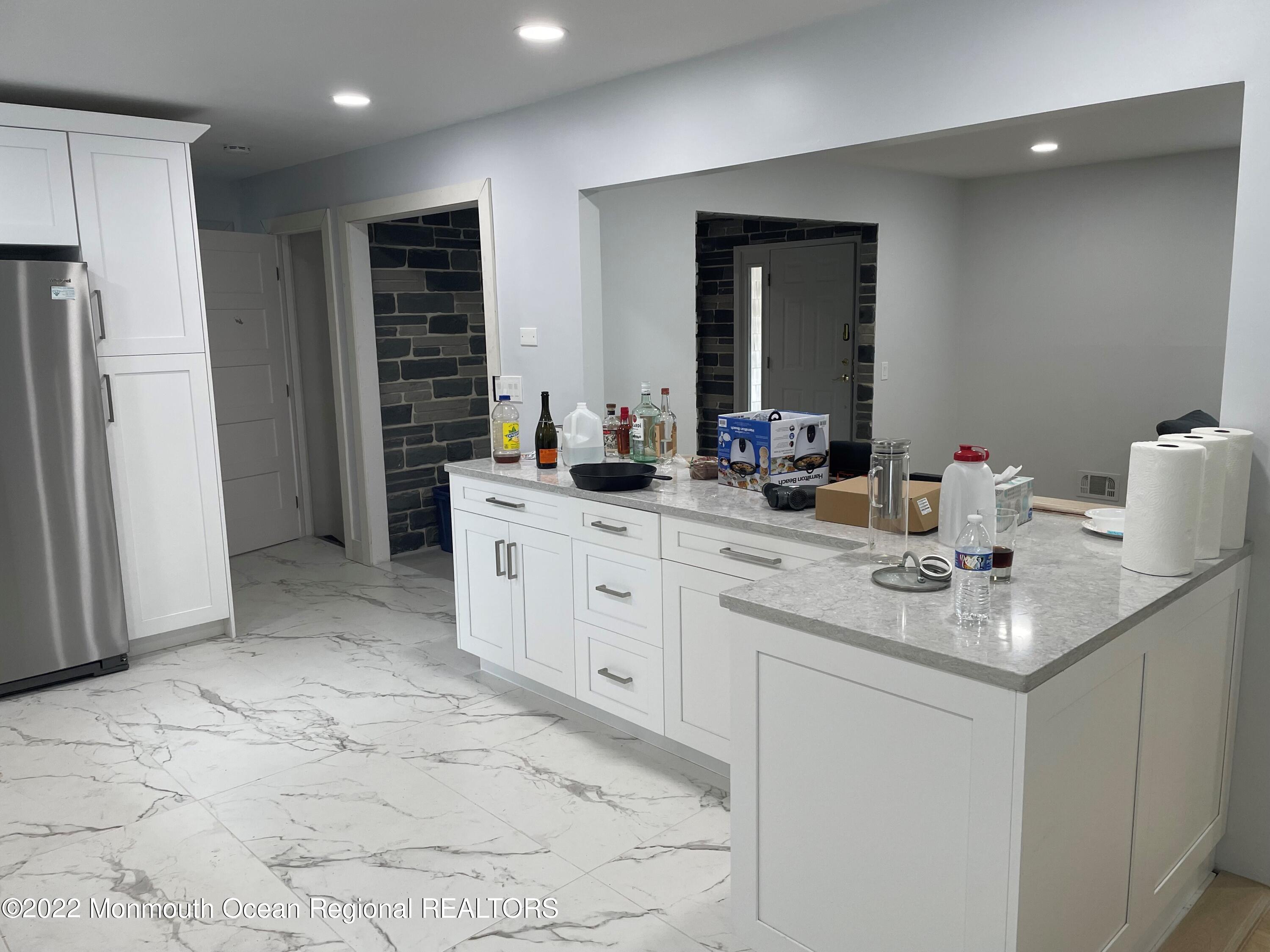 104 Pear Street, Unit WINTER Oakhurst, NJ 07755 - Photo 4 of 17 a kitchen with stainless steel appliances a sink stove and refrigerator