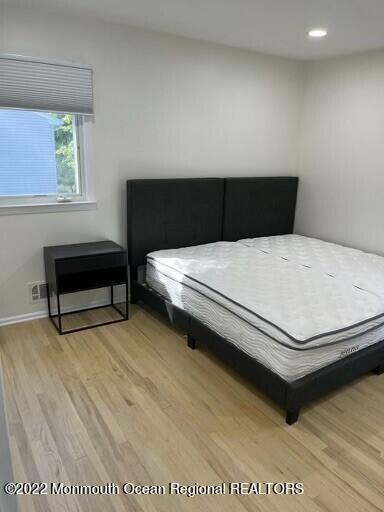 104 Pear Street, Unit WINTER Oakhurst, NJ 07755 - Photo 8 of 17 a bedroom with a bed table and a window