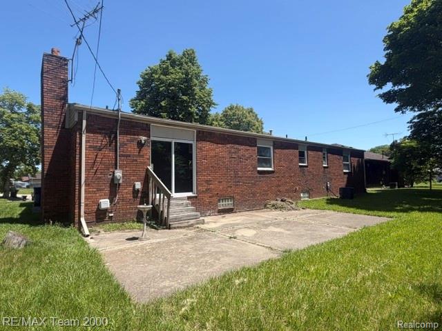580 Palmerston Street River Rouge, MI 48218 - Photo 3 of 19 Brick exterior with a prominent brick chimney and a concrete patio