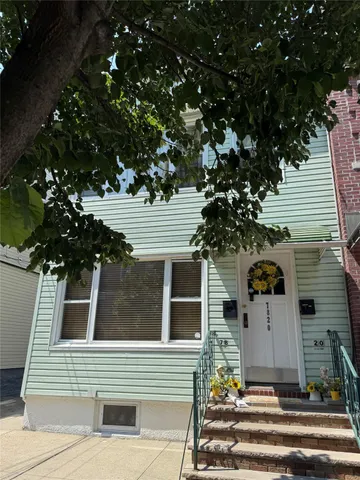 a front view of a house with a tree