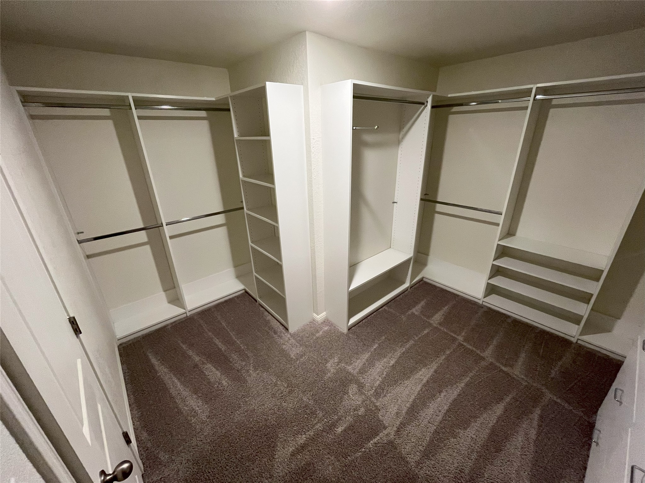 215 Light Timber Road Maxwell, TX 78656 - Photo 28 of 33 Custom built-in shelving and hanging rods maximize storage within this carpeted walk-in closet.