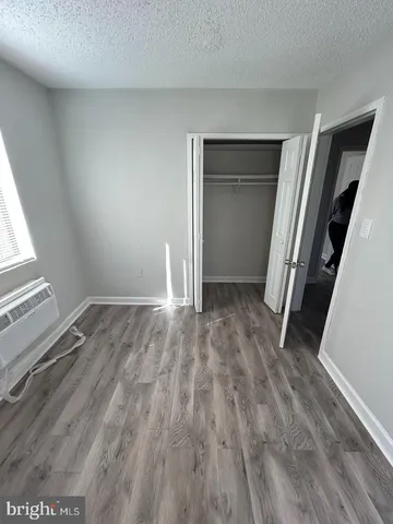 an empty room with wooden floor and closet