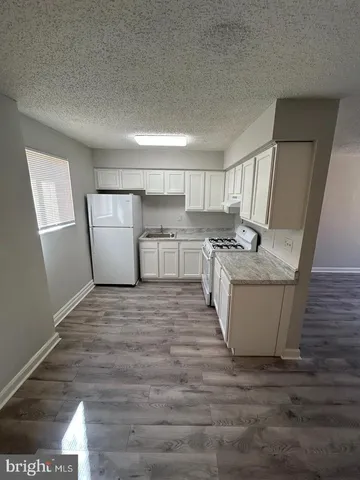 a room with a sink dishwasher stove and cabinets