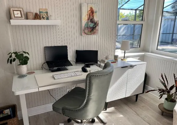 a work room with furniture and a flat screen tv