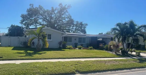 a view of a house with backyard and tree