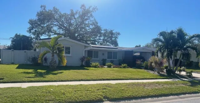 a view of a house with backyard and tree