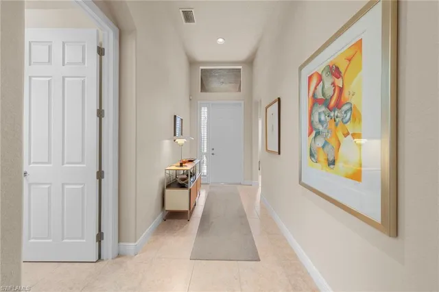 a living room with stainless steel appliances furniture a rug and a kitchen view