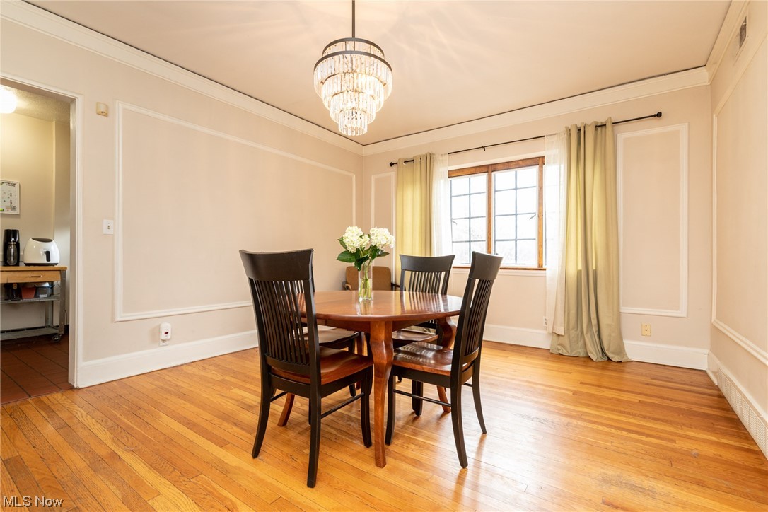 2515 Overlook Road, Unit 14 Cleveland, OH 44106 - Photo 8 of 20 Dining space with crown molding, light hardwood / wood-style floors, and an inviting chandelier