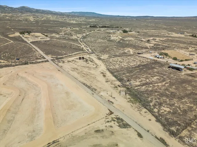 a view of a house with trees next to a road