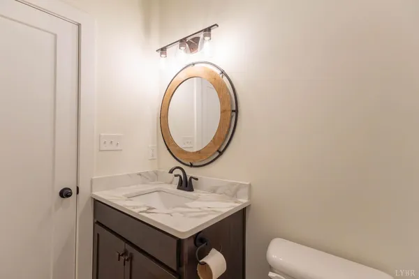a bathroom with a sink a light fixture and a mirror