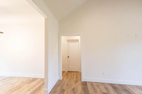 a view of an empty room with a chandelier fan