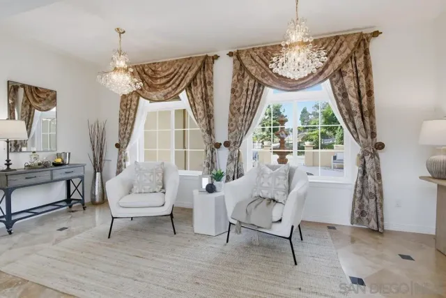 a living room with furniture a fireplace and a chandelier