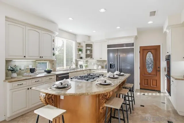 a kitchen with stainless steel appliances granite countertop a sink and a refrigerator