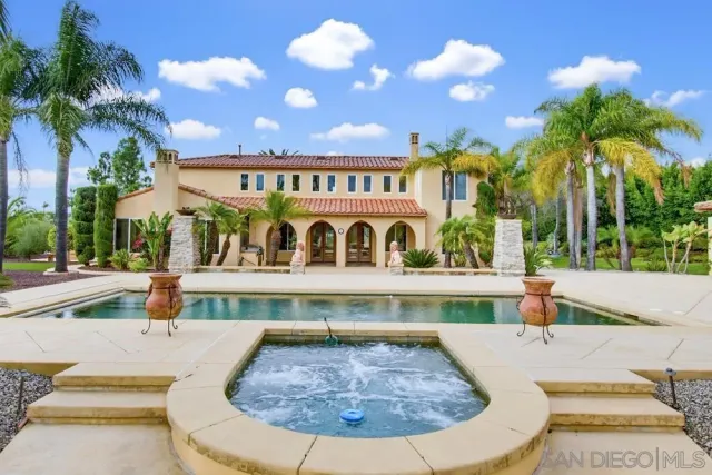 a view of a swimming pool with a garden and trees