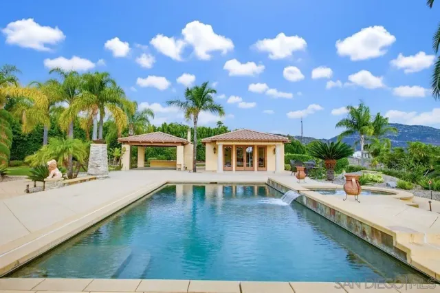 a view of a swimming pool with a patio and a yard