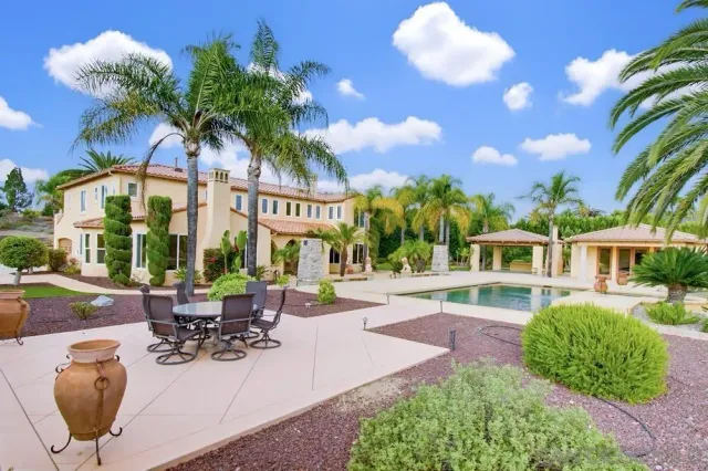 a view of a patio with couches table and chairs and potted plants