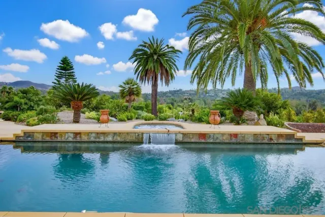 a living room with furniture a chandelier and a large mirror