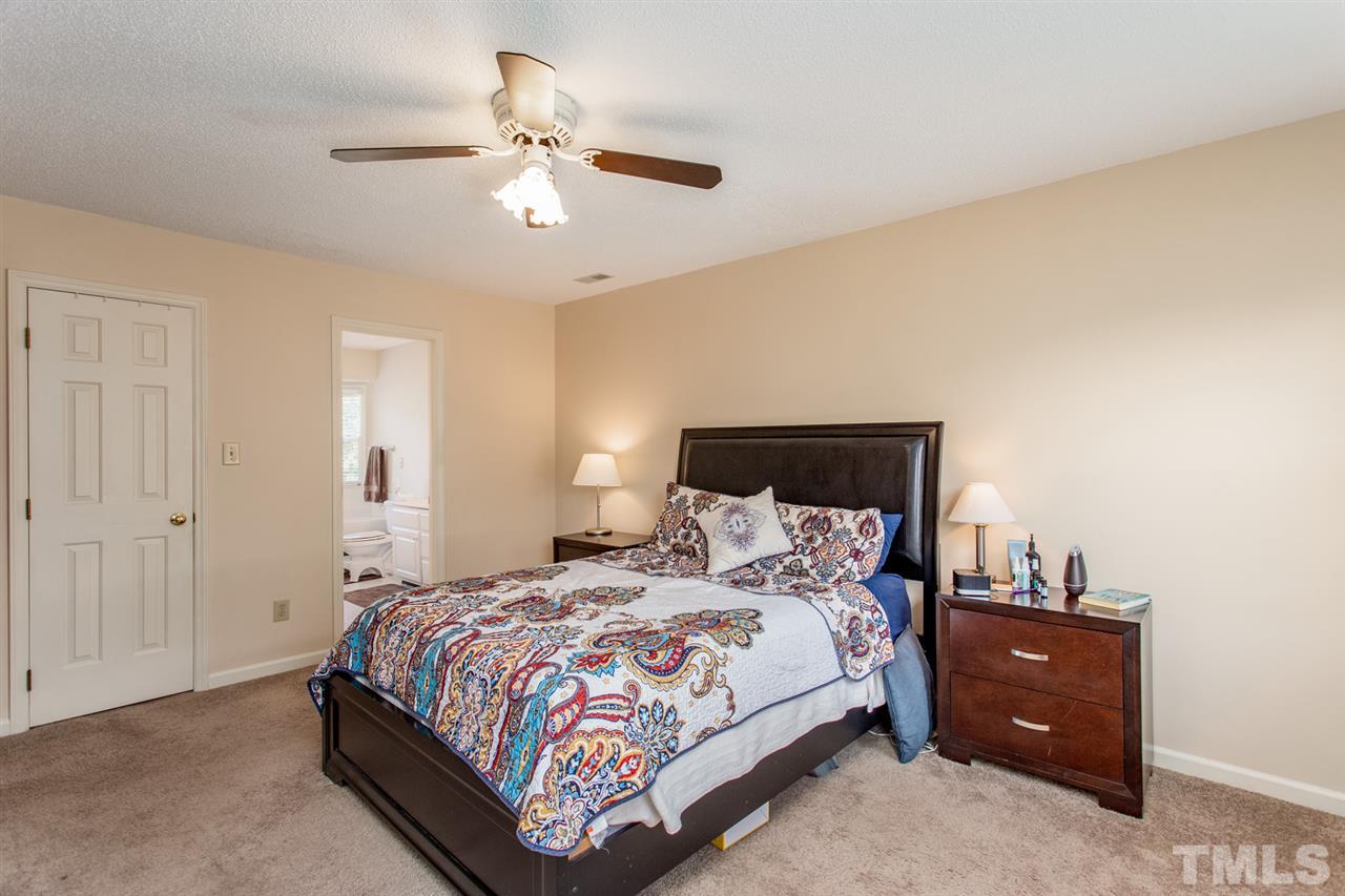 2300 Declaration Drive Raleigh, NC 27615 - Photo 14 of 30 a bedroom with a bed and a chandelier