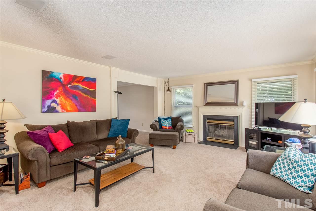 2300 Declaration Drive Raleigh, NC 27615 - Photo 3 of 30 a living room with furniture a fireplace and a flat screen tv