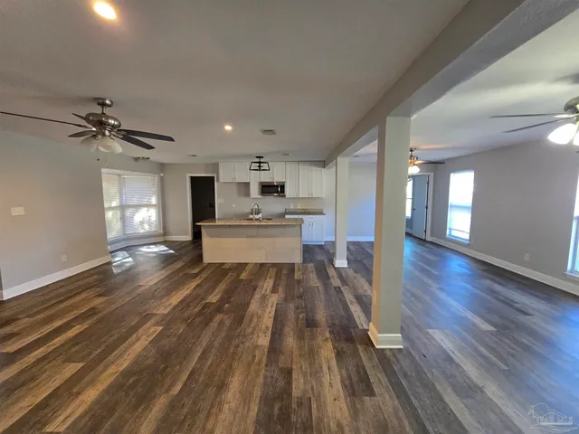a view of a living room hardwood floor and a kitchen