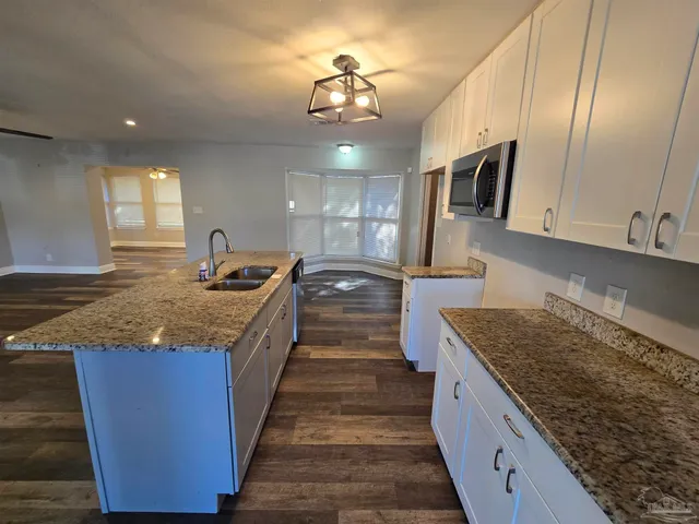 a kitchen with kitchen island granite countertop a sink and counter space