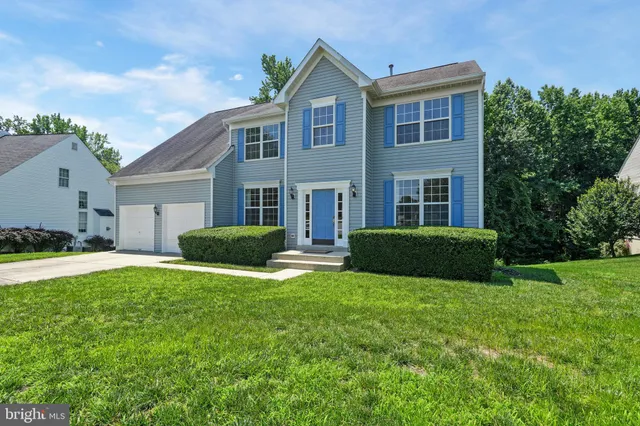a view of a house with a big yard and large trees