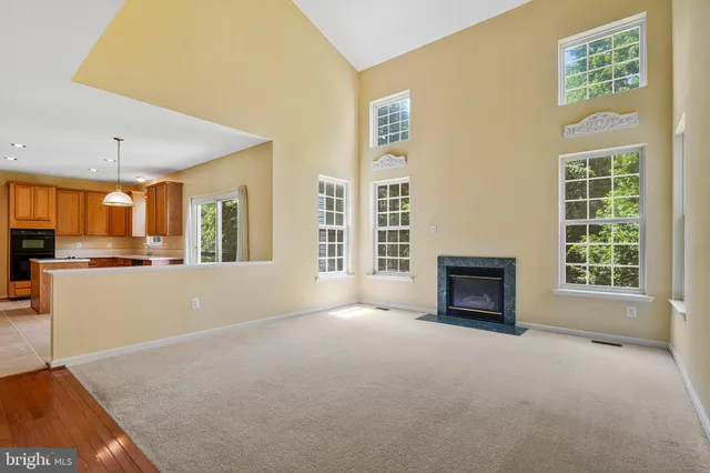 a view of an empty room with a fireplace and a window