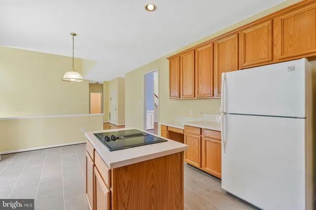 a kitchen with stainless steel appliances granite countertop a refrigerator a sink dishwasher a stove with white cabinets and wooden floor