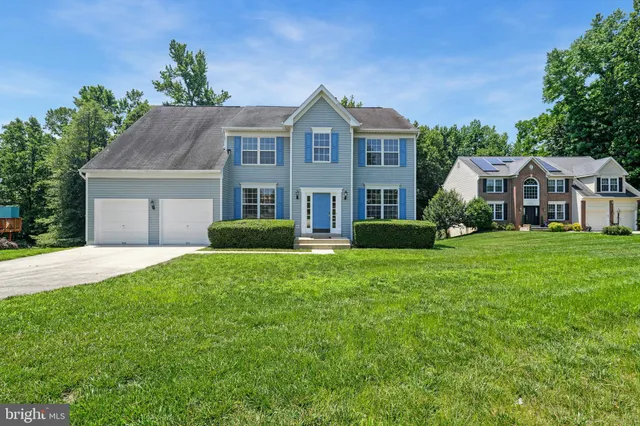 a front view of a house with a yard and trees