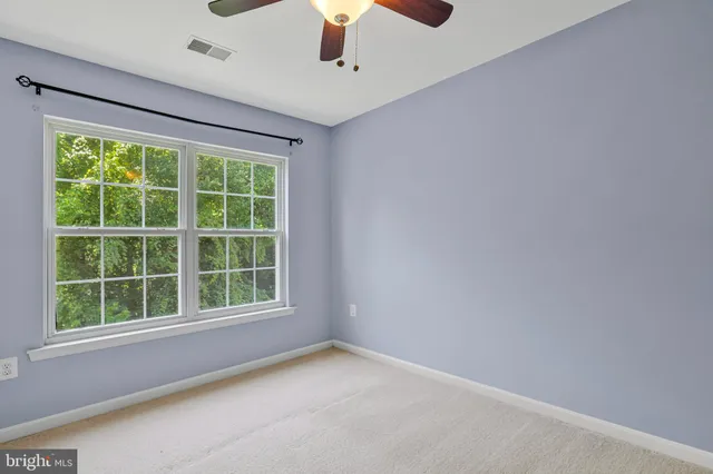 an empty room with a chandelier fan