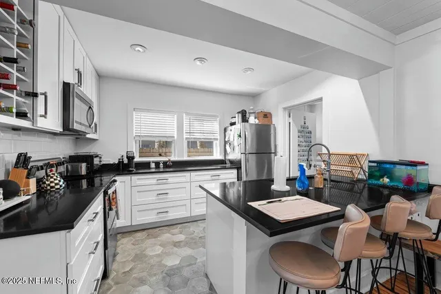 a large bedroom with a bed dresser and a large window