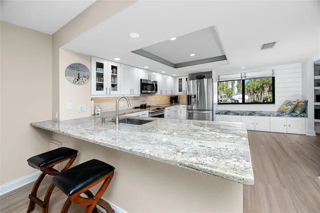 a kitchen with stainless steel appliances granite countertop sink stove and refrigerator