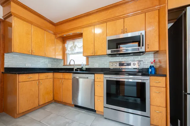 a kitchen with stainless steel appliances granite countertop a stove microwave and sink