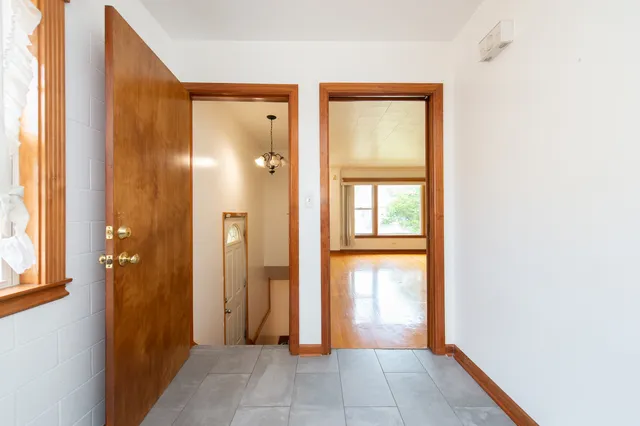 a view of a hallway with wooden floor and a bathroom