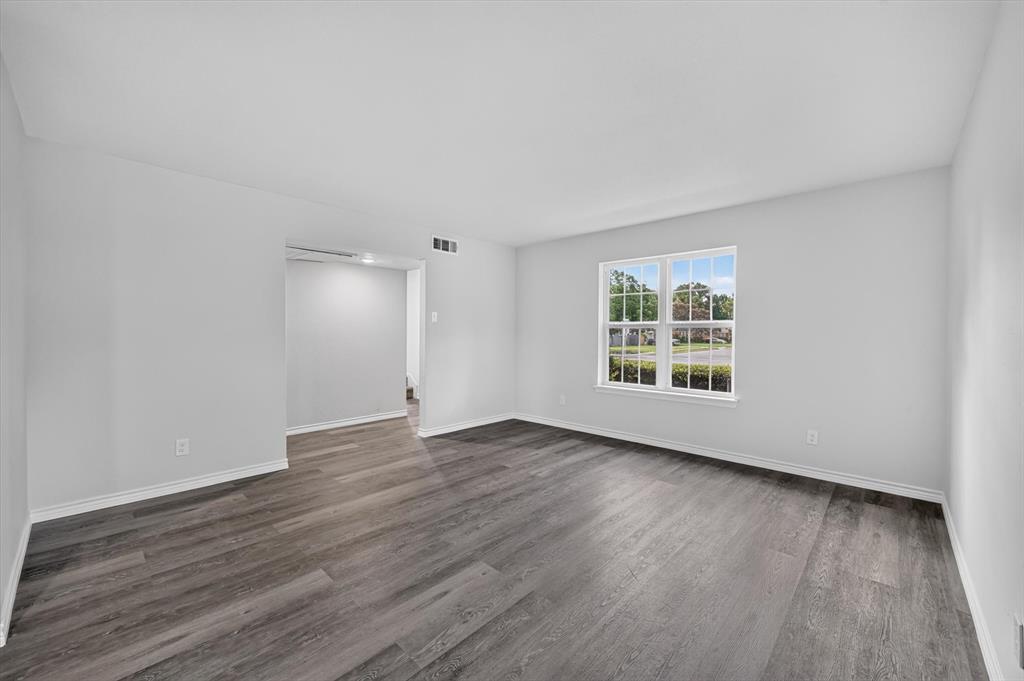 1801 East Grauwyler Road, Unit 101 Irving, TX 75061 - Photo 30 of 39 a view of an empty room with wooden floor and a window