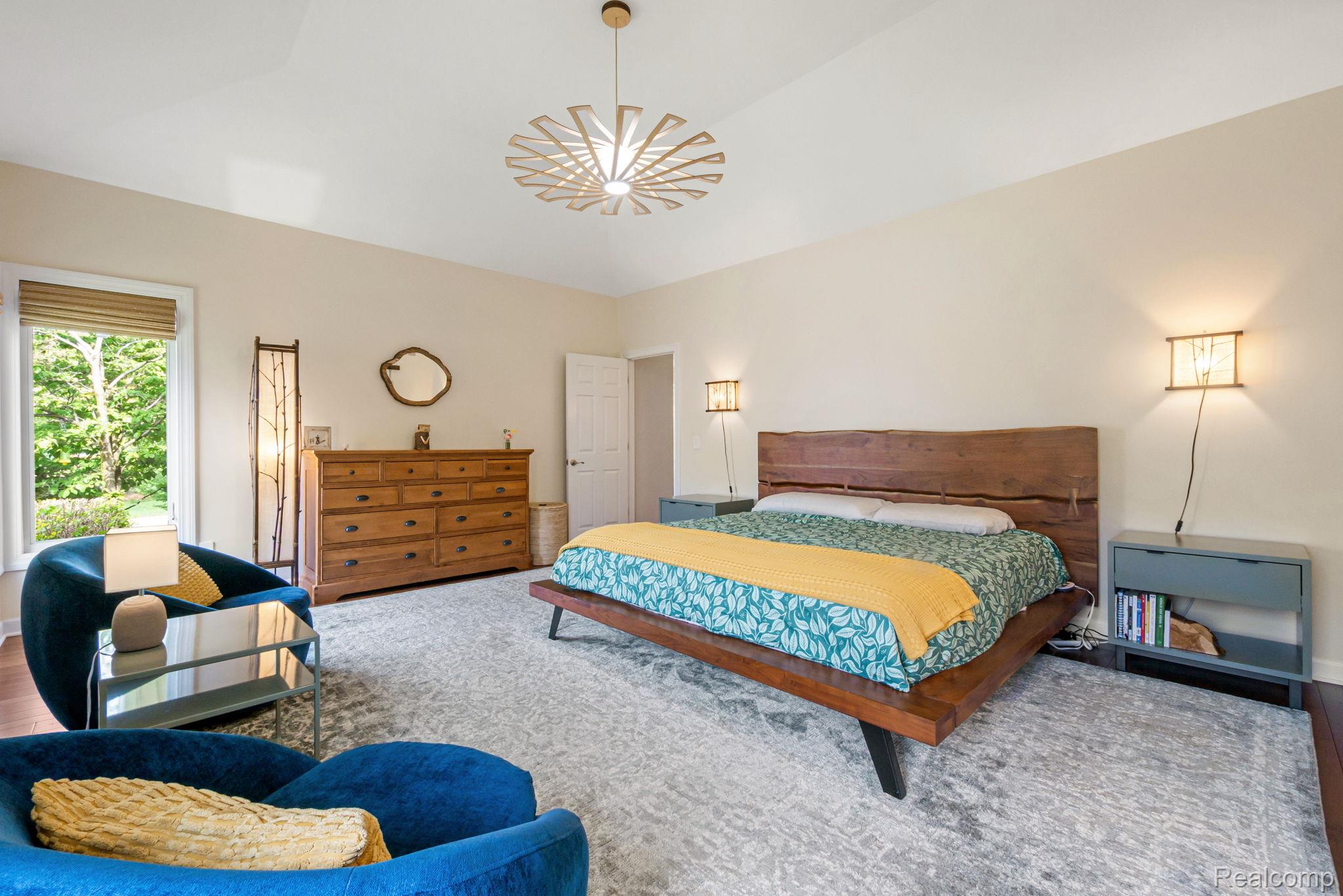 1902 Grayslake Drive Rochester, MI 48306 - Photo 27 of 76 Bedroom featuring vaulted ceilings, a large window, recessed wall sconces, wood-finish flooring, and a contemporary ceiling light fixture