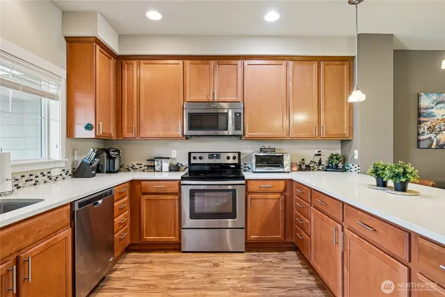 a kitchen with stainless steel appliances granite countertop wooden cabinets a sink and a stove