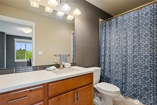 a bathroom with a sink a toilet and a mirror