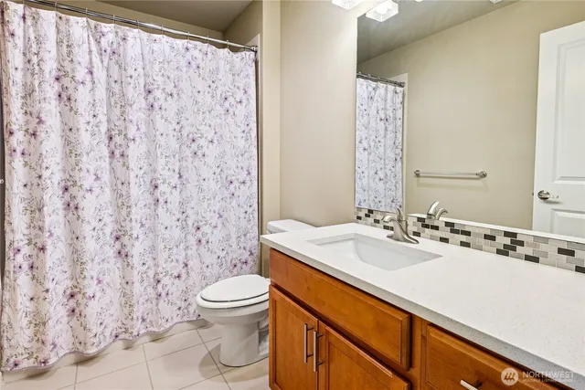 a bathroom with a sink a toilet and shower curtain
