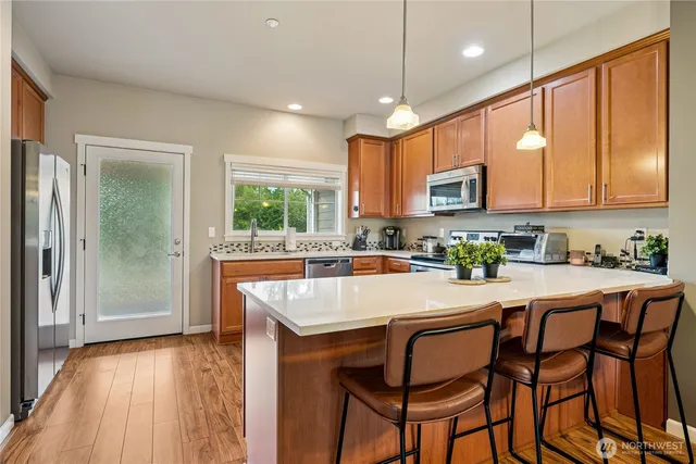 a kitchen with kitchen island granite countertop wooden floors and white cabinets
