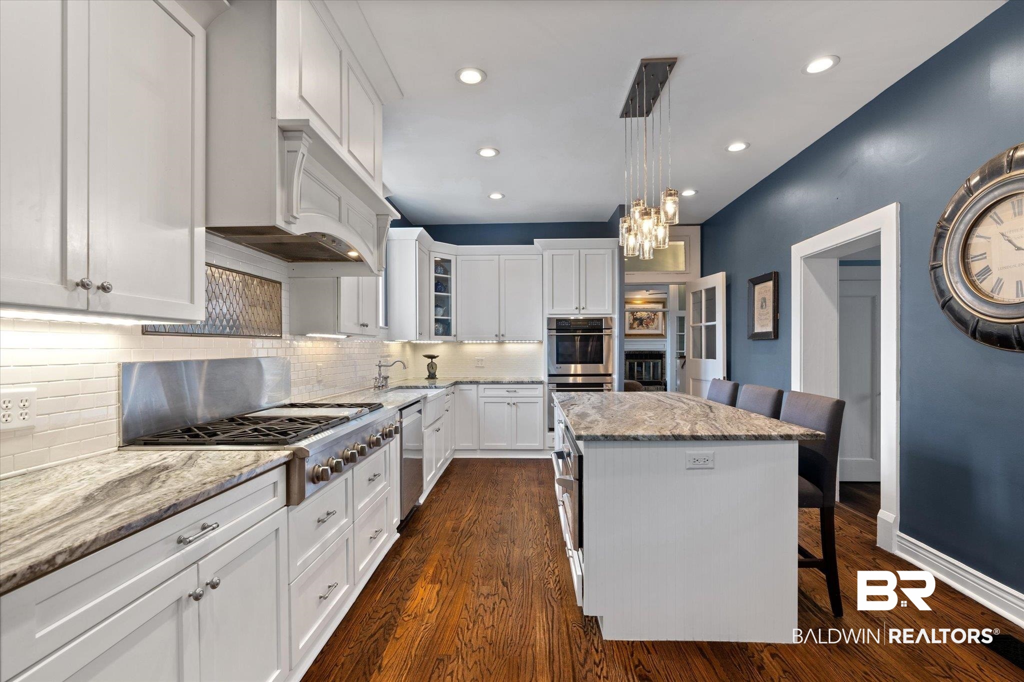 1953 Dauphin Street Mobile, AL 36606 - Photo 11 of 56 Kitchen featuring white cabinets, dark hardwood / wood-style flooring, a kitchen island, and a breakfast bar