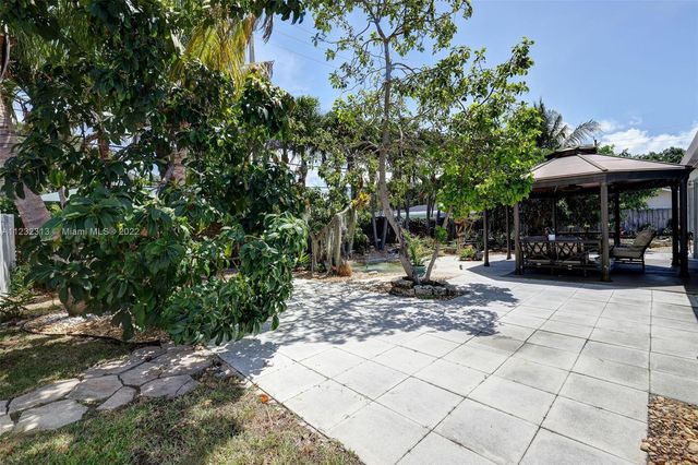 a view of a patio with table and chairs under an umbrella